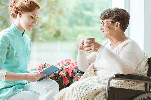 Caregiver with senior woman holding coffee