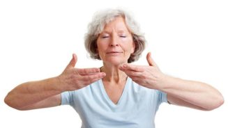 Senior woman stretching and breathing with eyes closed