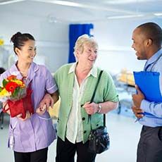 Woman being escorted from hospital after surgery